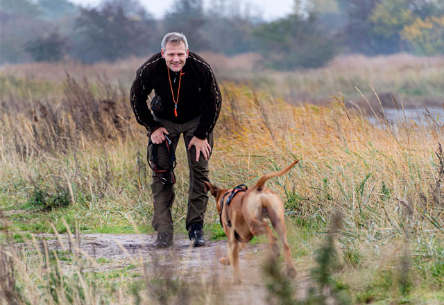 Man with dog in field.