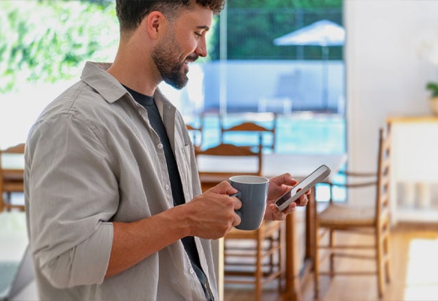 Man smiling at phone in his hand